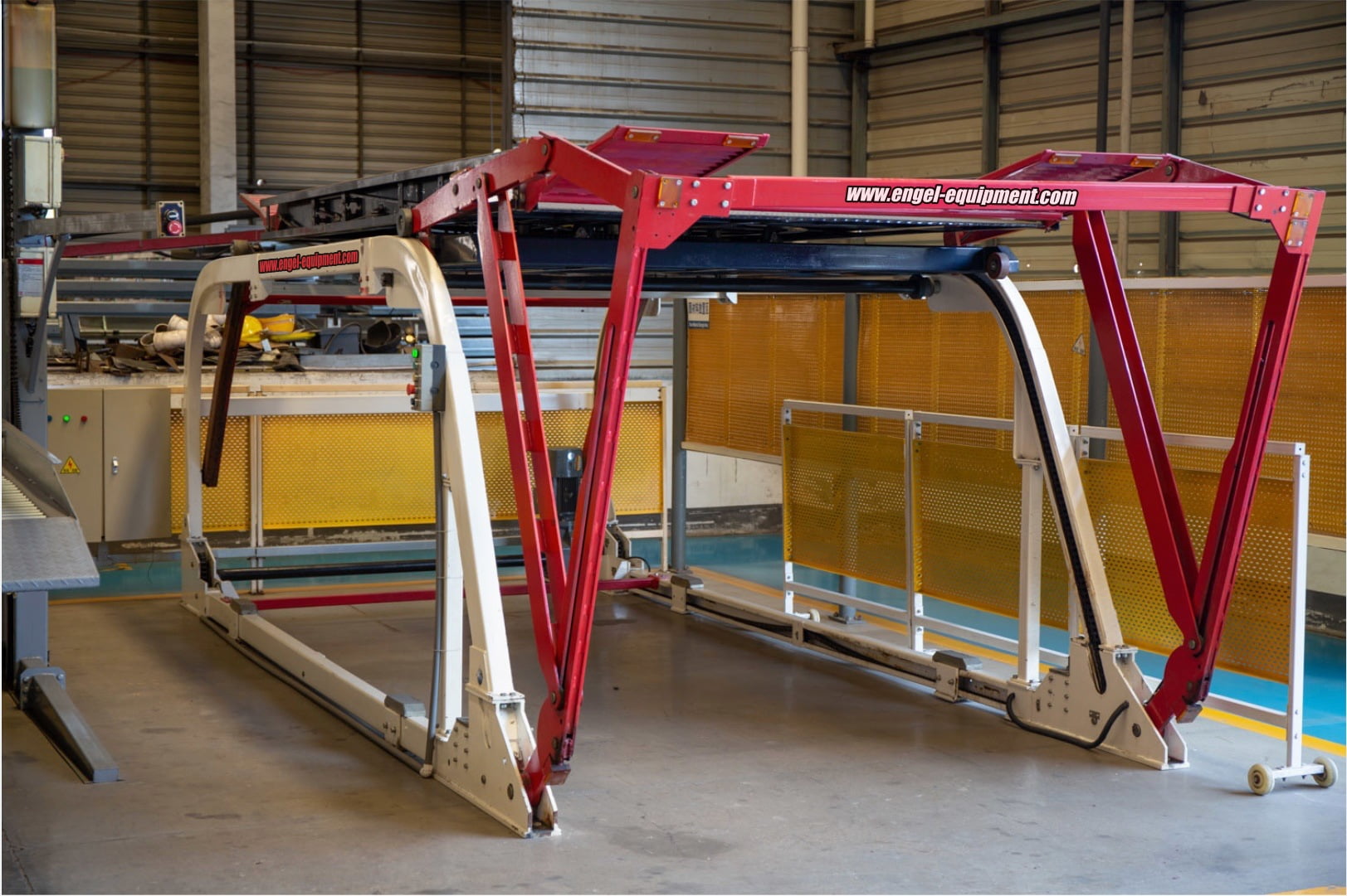 Red white and black car lift in a warehouse.